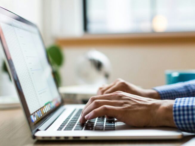 person typing on silver Macbook