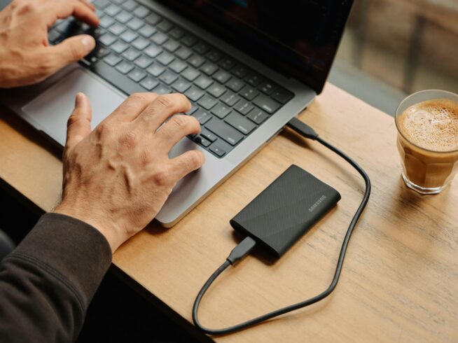 A man sitting at a table using a laptop computer