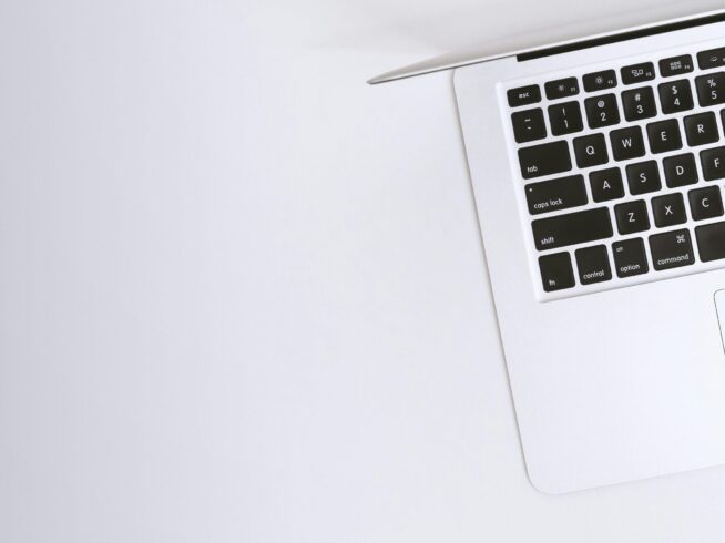Free Aerial view of a sleek laptop keyboard on a clean, white surface, ideal for tech backgrounds. Stock Photo